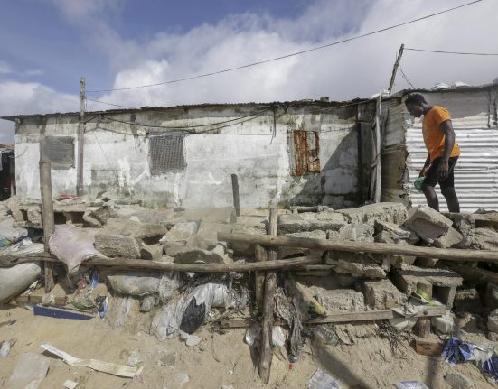A Liberian man walks along a community built protection wall against sea erosion in West Point coastal slum community in Monrovia, Liberia October 23, 2021. EPA/AHMED JALLANZO